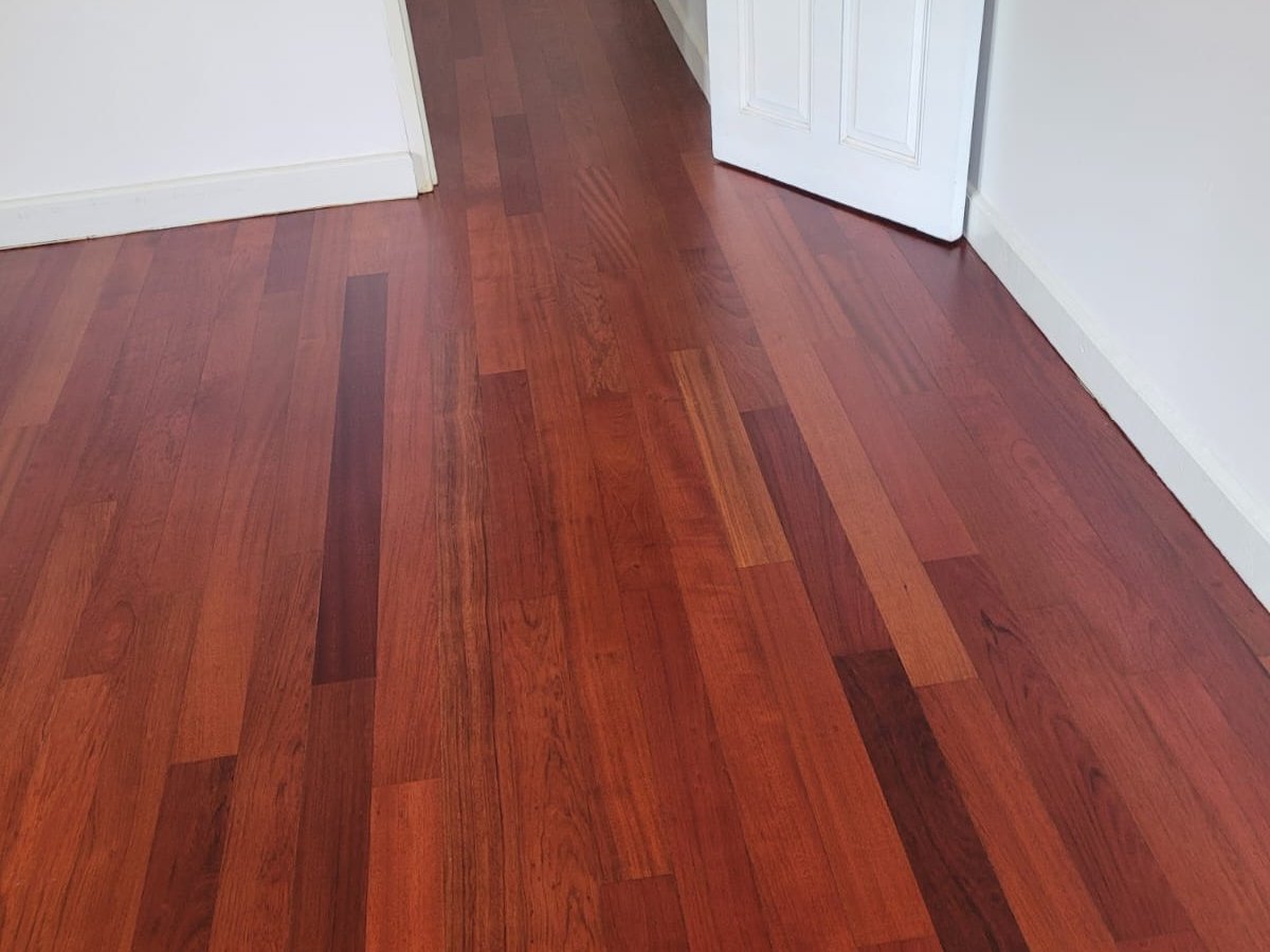 Newly installed hardwood floor with baseboards and door trim fitted